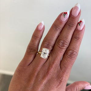 A close-up of a hand wearing a custom-made 14k gold elongated cushion lab grown diamond solitaire engagement ring