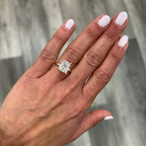 A close-up of a hand wearing a custom-made 14k gold square cushion lab grown diamond solitaire engagement ring 